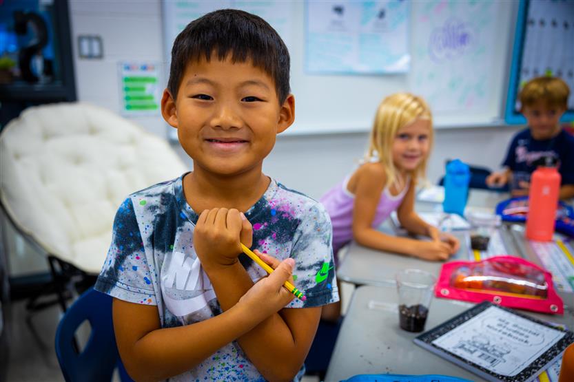 A boy smiles during a science experiment